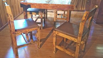 Una mesa de madera para comer con seis sillas, cada una con asiento y respaldo acolchados.