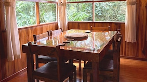 Une pièce aux murs lambrissés, comprenant une table à manger, des chaises et un lustre.