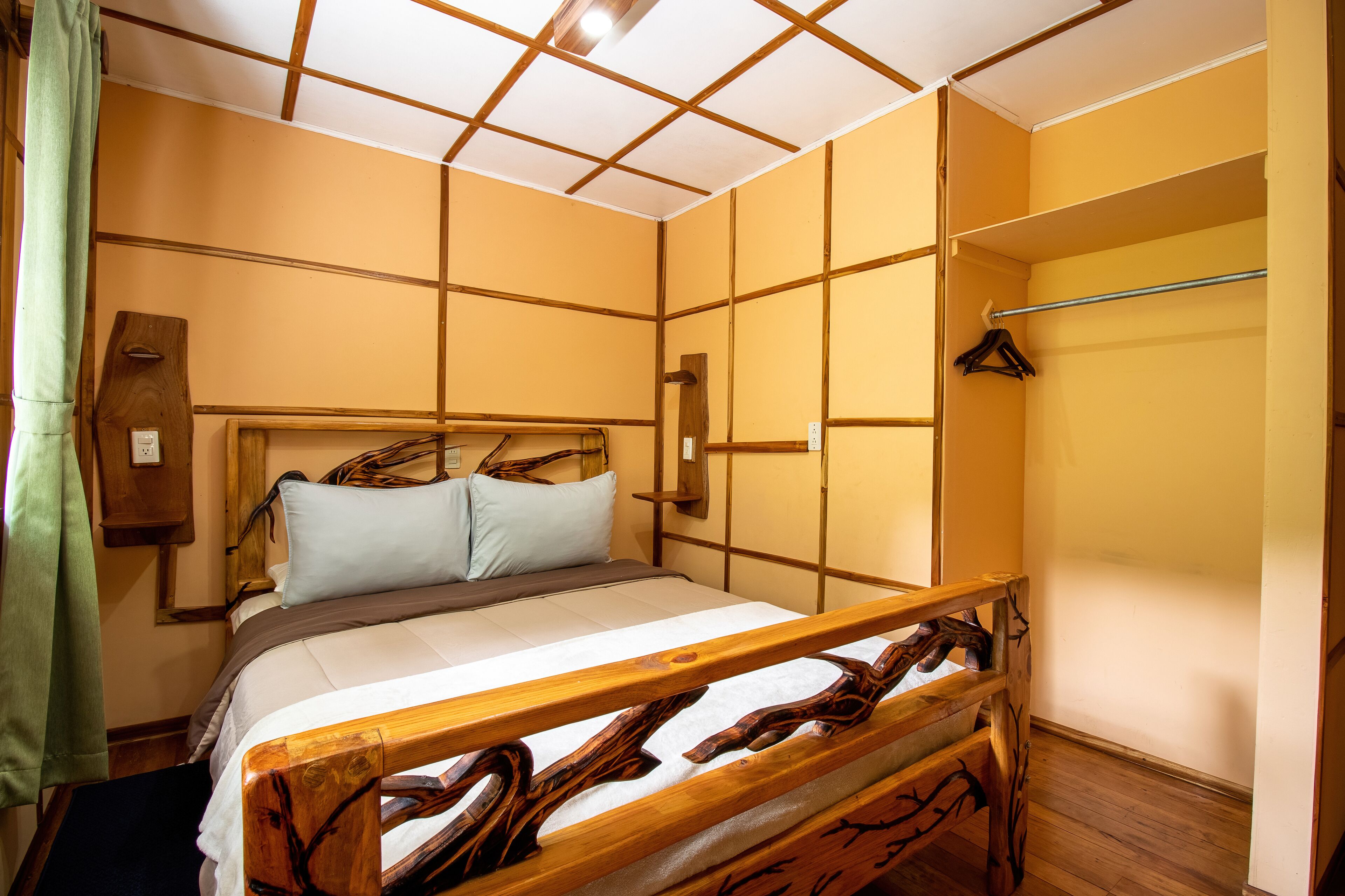 Una habitación con una cama, cabecero de madera y un banco de madera.