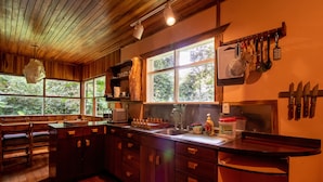 Une cuisine avec des meubles en bois, un évier et une fenêtre donnant sur un espace verdoyant.