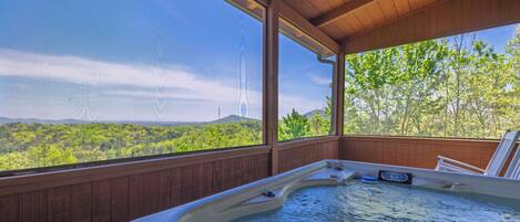 Ein Whirlpool mit Blick auf einen Wald und Berge.