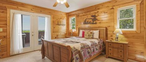 Una habitación de madera con una cama, una mesita de noche, una lámpara y un ventilador de techo.