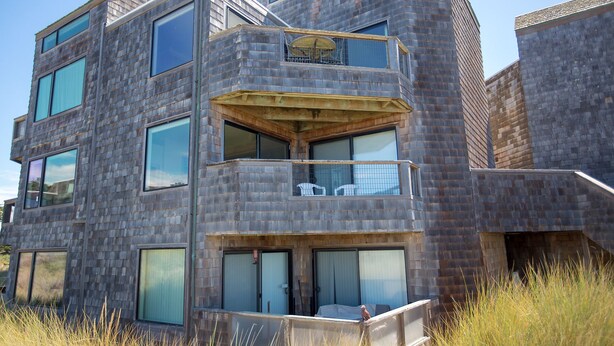Un immeuble moderne à plusieurs étages, doté d’une architecture originale, de grandes fenêtres et d’un balcon.