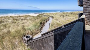 Une promenade en bois qui mène à une plage d’où l’on a une vue dégagée sur l’océan.