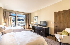 A hotel room with two beds, a desk, a television, and a view of the outdoors. - Charlie's Slopeside: Ski-In/Out, Ski Valet, Resort Amenities, Pool + Hot Tubs (Avon)