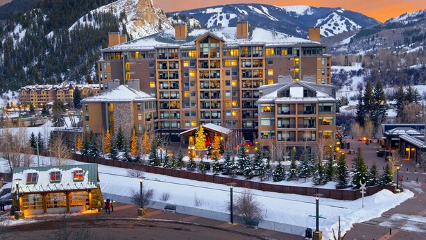 A multi-story hotel with a central courtyard, surrounded by snow-covered mountains and trees. - CRBC - Best View in Resort! Ski In/Out, 2 Queen Beds, Spa, Ski Valet, PvtBalcony (Avon)
