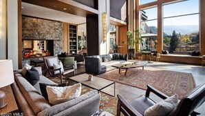 A spacious living area with a fireplace, comfortable seating, and large windows offering a view of the mountains. - CRBC - Best View in Resort! Ski In/Out, 2 Queen Beds, Spa, Ski Valet, PvtBalcony (Avon)