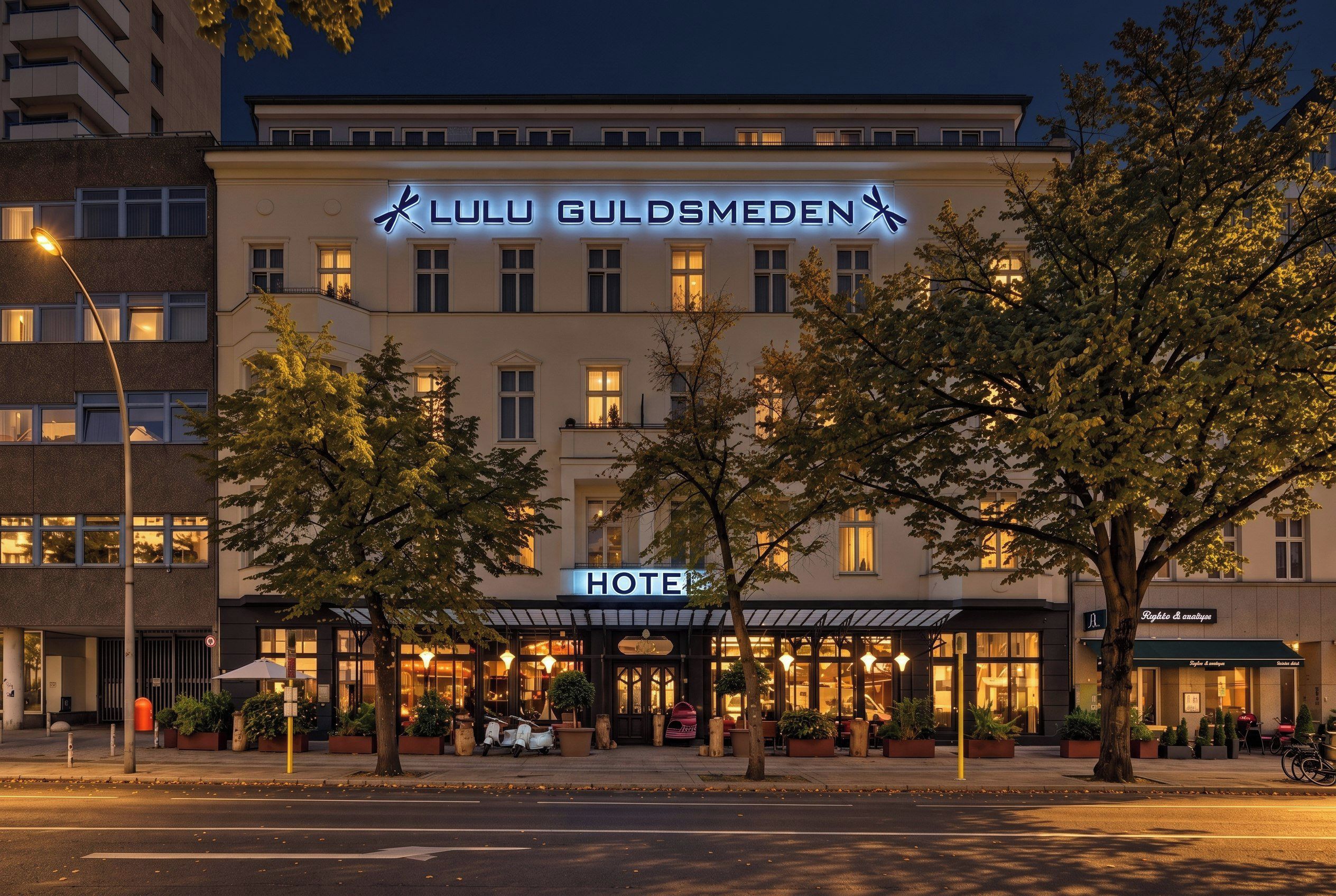 Ein Hotel mit einem gut sichtbaren Schild, auf dem 'Lulu Guldsmeden' steht, und einem Schild mit der Aufschrift 'HOTEL' darunter.