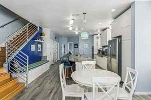 Une cuisine moderne avec un coin repas, un escalier et un banc intégré.