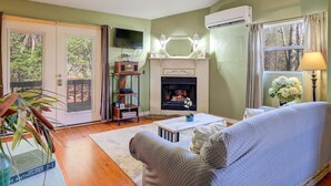 A living room with a fireplace, a sofa, a television, and a bookshelf.