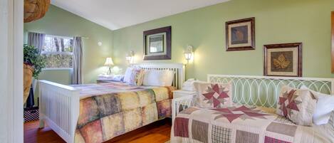 A bedroom with two beds, a radiator, a window with curtains, and wall-mounted lamps.