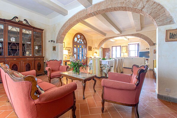 A spacious living room with a high ceiling, a fireplace, and a dining area with a large table and chairs. - Authentic Private Tuscan Villa for 12 people in Greve: the Heart of Chianti (Greve in Chianti (Firenze))