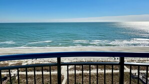 A beach view from a balcony with a railing, sandy beach, and ocean. - "Direct" Ocean Front 9th Floor cozy coastal cottage Reasonable Rates (Myrtle Beach)