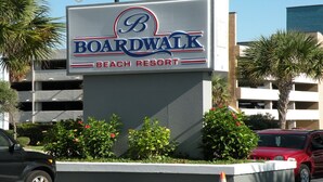 A sign for Boardwalk Beach Resort with a parking garage in the background. - "Direct" Ocean Front 9th Floor cozy coastal cottage Reasonable Rates (Myrtle Beach)