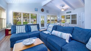 A spacious living room with a large sectional sofa, a wooden coffee table, and a ceiling fan.
