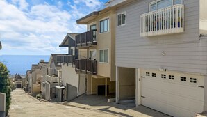 Un immeuble résidentiel doté d’un garage, d’un balcon et offrant une vue sur l’océan.