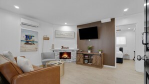 Un salon avec une cheminée, un téléviseur et un canapé.