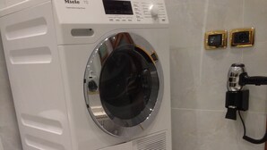 A stacked washer and dryer unit in a bathroom with a tiled wall and a towel rack. - SPLENDID STAR SAN MARCO SQUARE - Magic Dream ! All Inclusive Options-WIFi (Venice)
