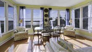 A room with a dining table and chairs, a sofa, and a window with curtains. - Waterfront Mansion 6BR Sleeps 18 Game RM
Hot Tub & SUNSET VIEWS elevator Access (Atlantic City)