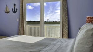 A bedroom with a large window, a bed, and a view of a body of water. - Waterfront Mansion 6BR Sleeps 18 Game RM
Hot Tub & SUNSET VIEWS elevator Access (Atlantic City)