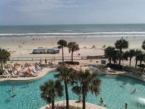 Relax by the pool surrounded by palm trees and enjoy stunning ocean views.