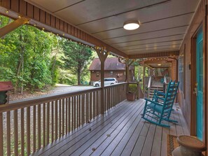 A wooden porch with a railing, a rocking chair, and a potted plant. - Country Charm D - Cozy Pet Friendly Cabin in Helen (Helen)