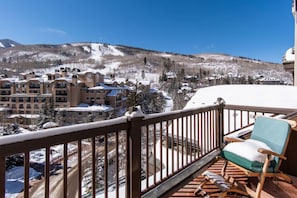 A balcony with a view of a snow-covered mountain and a resort building. - Charlie's Slopeside: Ski-In/Out Penthouse, Sleeps 12, 3,040 Sq Ft, AC, BC Village, Walk Everywhere (Beaver Creek)