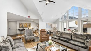 A spacious living room with a high ceiling, a large window, and a modern ceiling fan. - Charlie's Slopeside: Ski-In/Out Penthouse, Sleeps 12, 3,040 Sq Ft, AC, BC Village, Walk Everywhere (Beaver Creek)