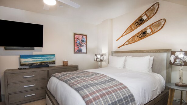 A bedroom with a bed, a television, a painting, two lamps, and a wall-mounted shelf. - Charlie's Slopeside: Ski-In/Out Penthouse, Sleeps 12, 3,040 Sq Ft, AC, BC Village, Walk Everywhere (Beaver Creek)
