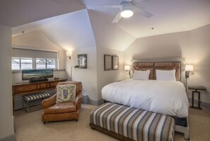 A hotel room with a large bed, a desk with a television, a leather armchair, and a bench. - Charlie Rentz: Ski-In/Out Penthouse, Sleeps 12, 3,040 Sq Ft, AC, BC Village, Walk Everywhere (Beaver Creek)