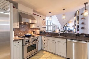 A modern kitchen with stainless steel appliances, white cabinetry, and a granite countertop. - Charlie's Slopeside: Ski-In/Out Penthouse, Sleeps 12, 3,040 Sq Ft, AC, BC Village, Walk Everywhere (Beaver Creek)
