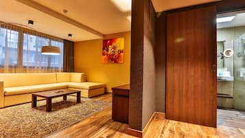A modern living room with a sofa, a coffee table, and a painting on the wall.