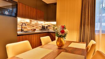 Una cocina moderna con extractor Bosch, salpicadero de madera y comedor con mesa y sillas de madera.