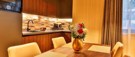 A modern kitchen with a Bosch range hood, a wooden backsplash, and a dining area with a wooden table and chairs.