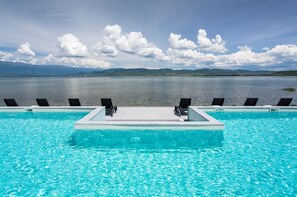 Piscina com vista para montanhas e um lago.