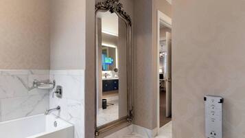 Un baño moderno con un espejo grande, una bañera y un perchero para toallas.