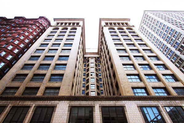 A high-rise building with a symmetrical facade, featuring a central section with a distinct architectural design. - Hotel Saint Louis, Autograph Collection (St. Louis)