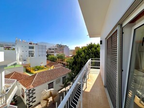 A balcony with a view of a cityscape, including buildings with red-tiled roofs and a clear blue sky. - Hotel Eden La Palma (Los Llanos de Aridane)