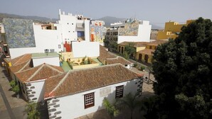 Zona residencial con edificios blancos, algunos con techos de tejas y otros con murales de colores.
