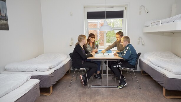 A dormitory room with bunk beds, a table, and a window. - Danhostel Ringkøbing (Ringkobing)