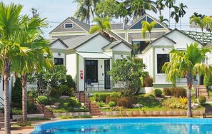 A row of modern, two-story villas with a swimming pool in the foreground. - Saichol Grandview (Ban Ta Khun)