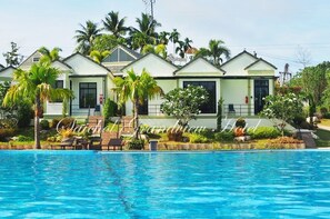 A hotel with multiple buildings, a swimming pool, and palm trees. - Saichol Grandview (Ban Ta Khun)
