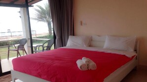 A hotel room with a bed, a balcony, and a table with chairs. - Saichol Resort (Chumphon)