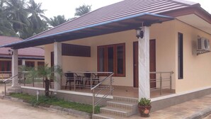 A building with a covered porch, a staircase, and a potted plant. - Saichol Resort (Chumphon)