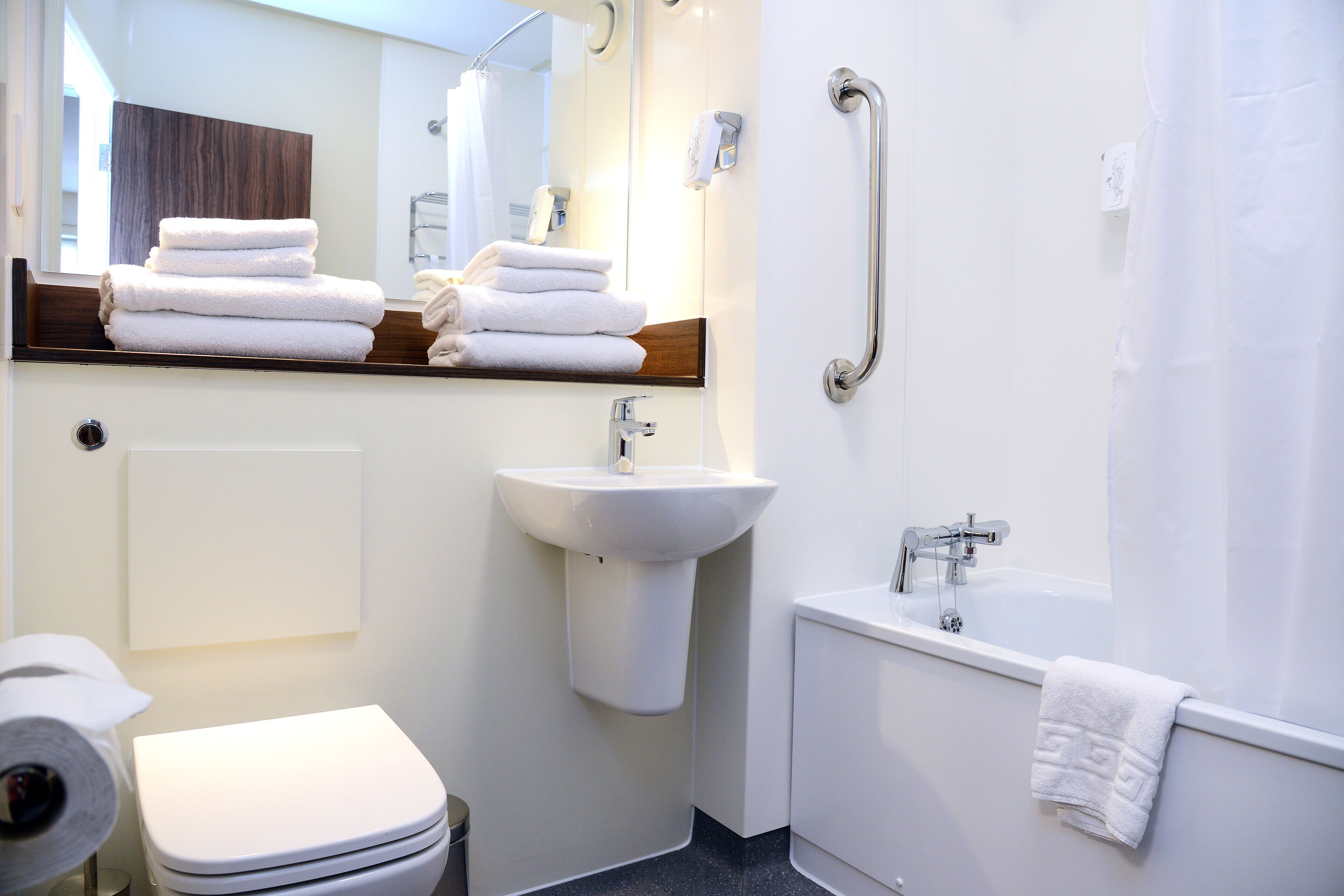 A modern bathroom with a toilet, sink, and bathtub.