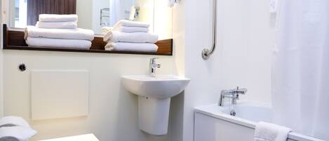 A modern bathroom with a toilet, sink, and bathtub.