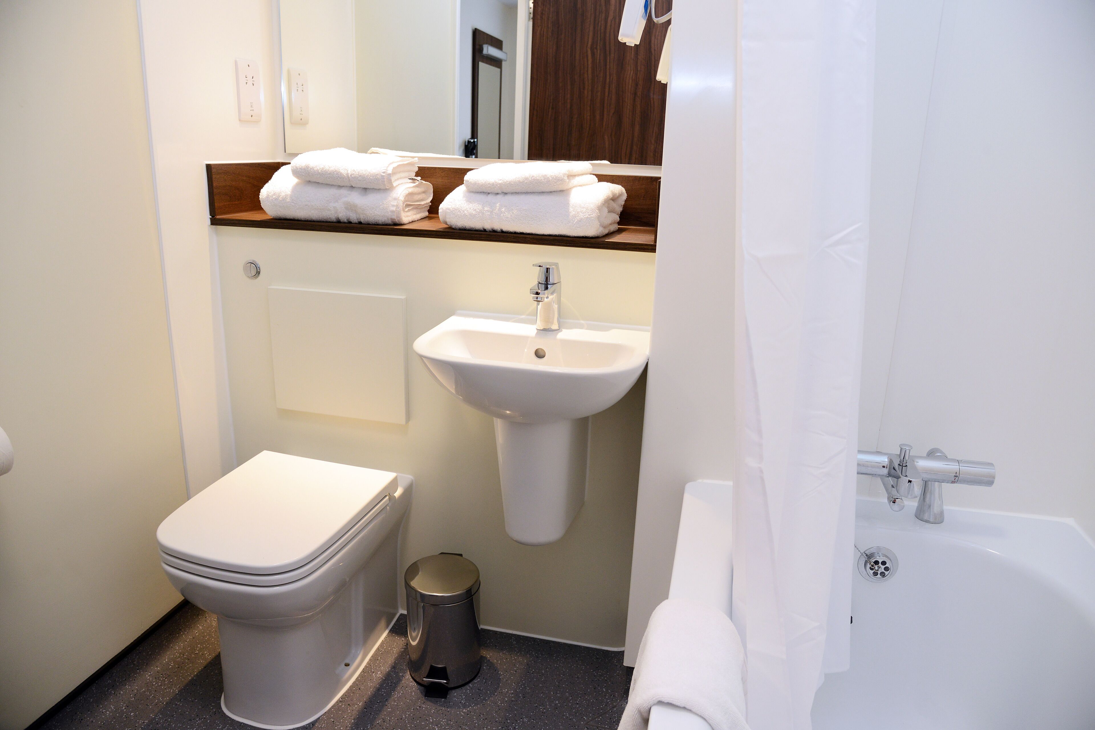 Ein modernes Badezimmer mit Toilette, Waschbecken und Badewanne.
