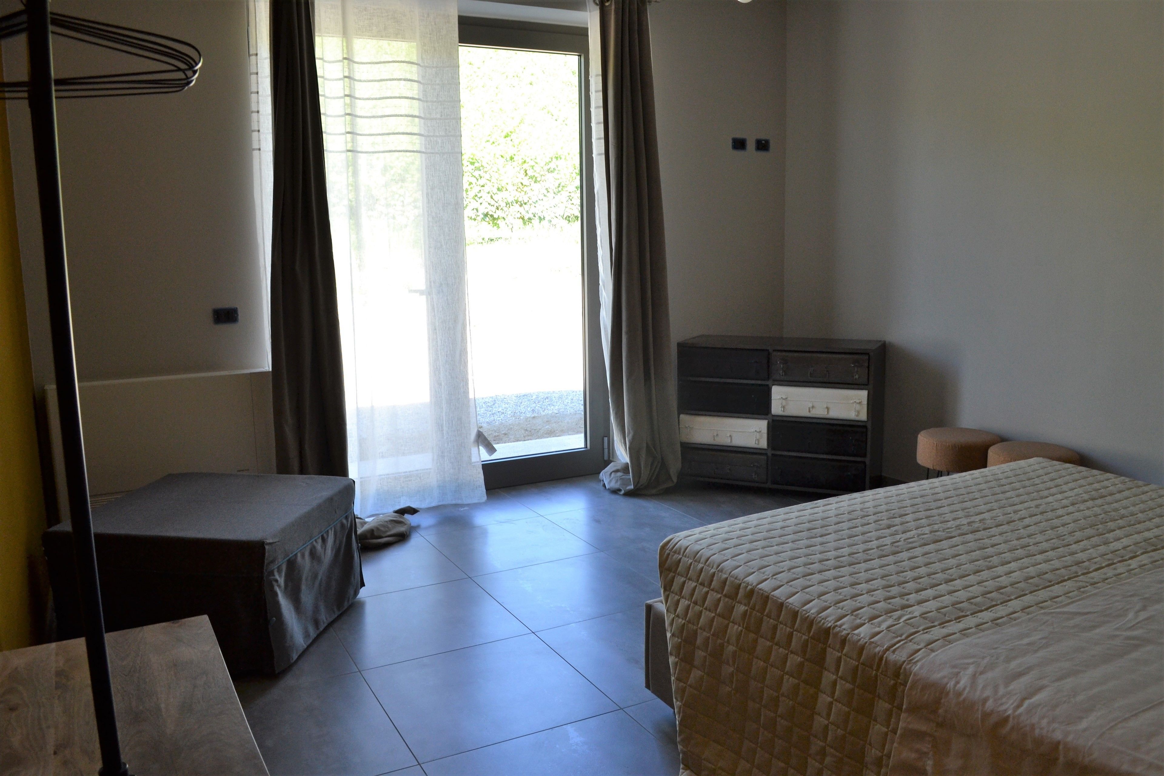 Un dormitorio con cama, cómoda y banco.