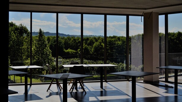 Un interior moderno con amplios ventanales que ofrecen vistas a un paisaje boscoso.