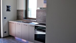 Una cocina moderna con ventana, electrodomésticos de acero inoxidable y un diseño minimalista.